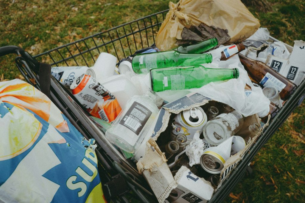 ein Müllhaufen neben einer blauen Mülltonne